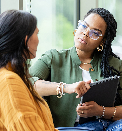 An empathetic female counselor listens as a vulnerable patient shares about a difficult situation.