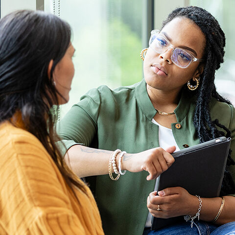 An empathetic female counselor listens as a vulnerable patient shares about a difficult situation.